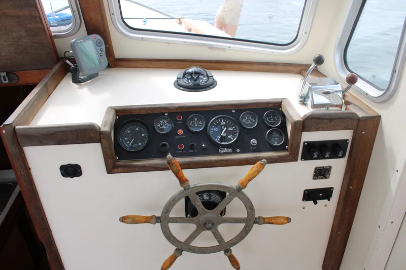 Slide: The Image of Helm of 1996 Webbers Cove 26 boat with gauges and wooden steering wheel. - 11