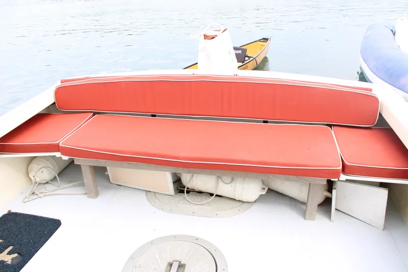 Slide: The Image of 1996 Webbers Cove 26 boat with red cushioned seating on deck. - 13