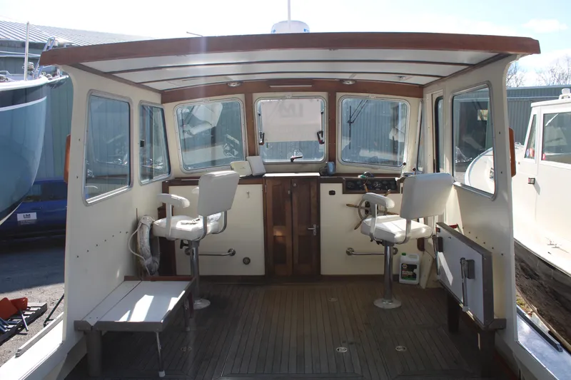 Slide: The Image of 1996 Webbers Cove 26 boat interior with seating and control panel. - 15