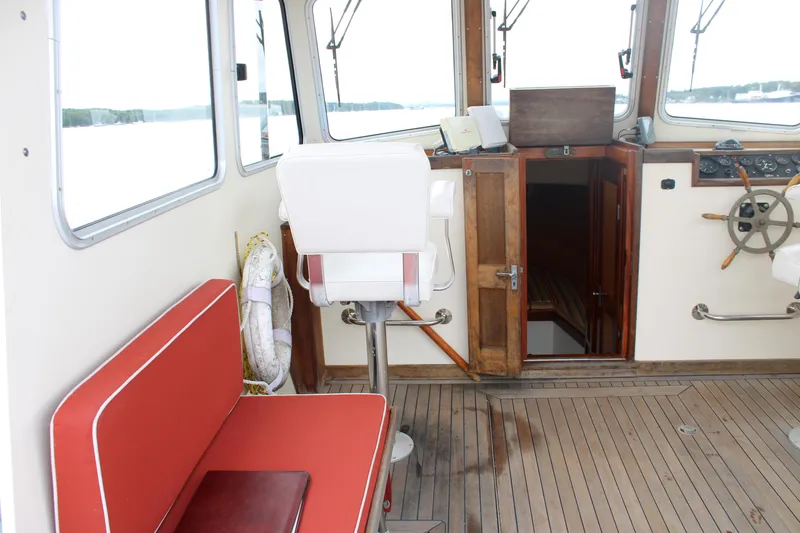 Slide: The Image of Interior of 1996 Webbers Cove 26 boat with red seating and wooden helm. - 16