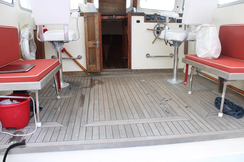 Slide: The Image of 1996 Webbers Cove 26 boat interior with red seating and wooden flooring. - 17