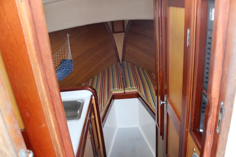 Slide: The Image of Interior of 1996 Webbers Cove 26 boat with wooden finish and striped cushions. - 18