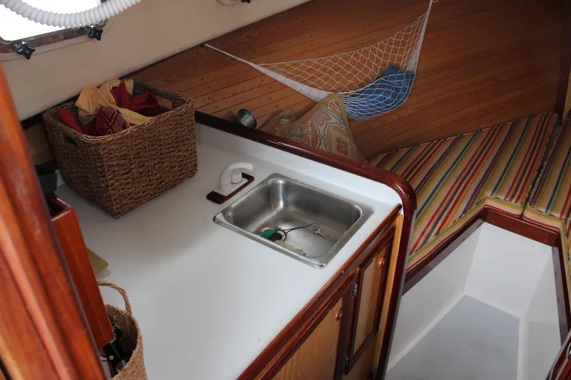 Slide: The Image of Cozy cabin interior of 1996 Webbers Cove 26 with sink, storage, and striped seating. - 20