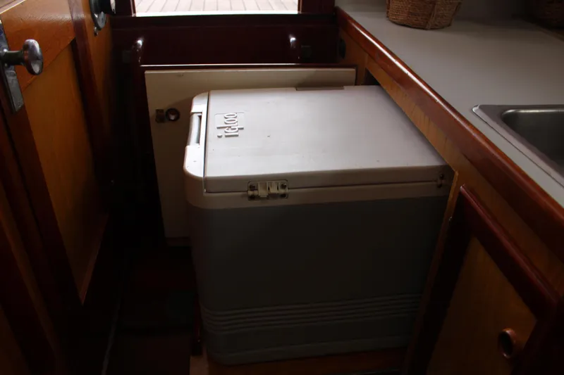 Slide: The Image of Interior of a 1996 Webbers Cove 26 boat featuring a compact galley with a cooler. - 23