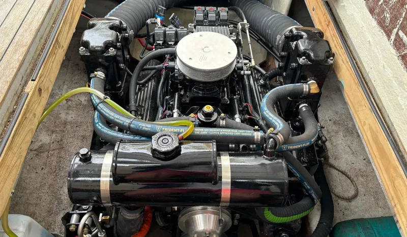 Slide: The Image of Engine of a 1996 Webbers Cove 26 boat, showcasing detailed components and hoses. - 26