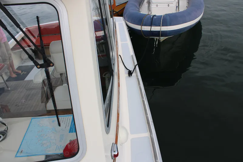 Slide: The Image of 1996 Webbers Cove 26 boat docked with inflatable dinghy nearby. - 32