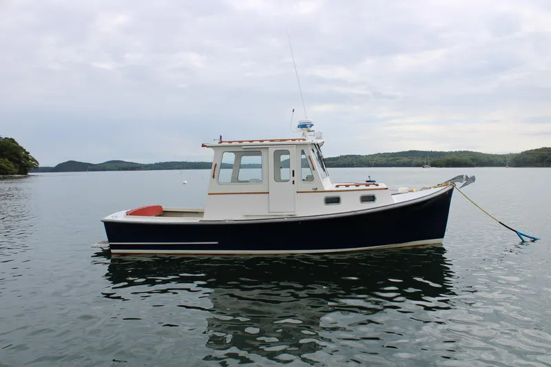 Slide: The Image of 1996 Webbers Cove 26 boat on calm water, overcast sky, scenic background. - 7