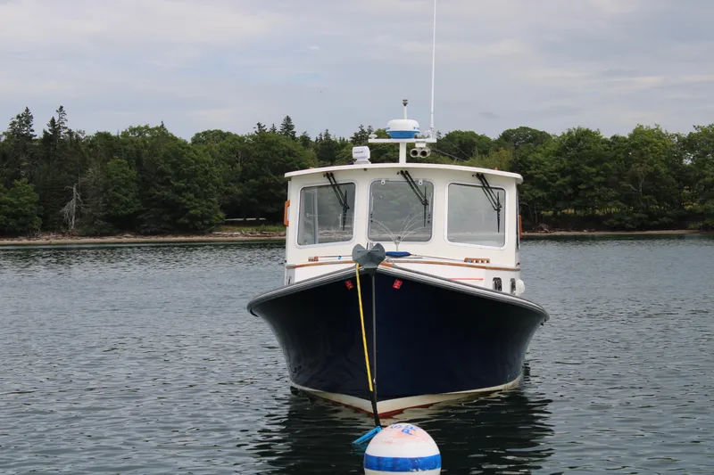 Slide: The Image of Webbers Cove 26 boat, 1996 model, anchored on calm water with forested shoreline. - 8