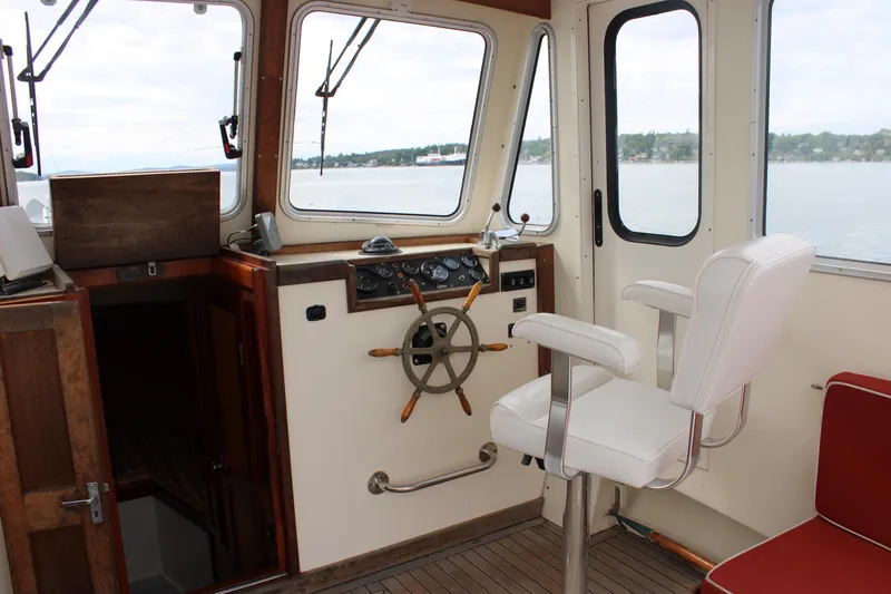 Slide: The Image of Interior of a 1996 Webbers Cove 26 boat with steering wheel and captain's chair. - 9