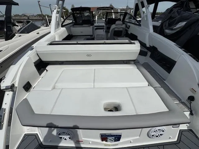Slide: The Image of 2024 Cobalt R8 boat interior with spacious seating and modern design at a marina. - 11