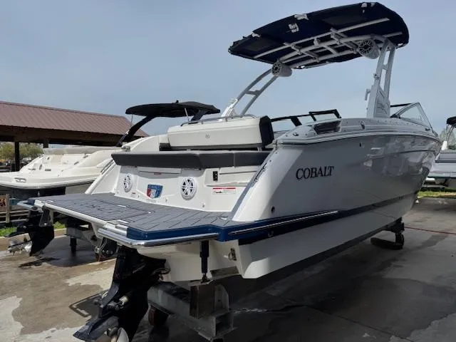 Slide: The Image of 2024 Cobalt R8 boat with sleek design, docked outdoors, featuring a spacious deck and modern amenities. - 2