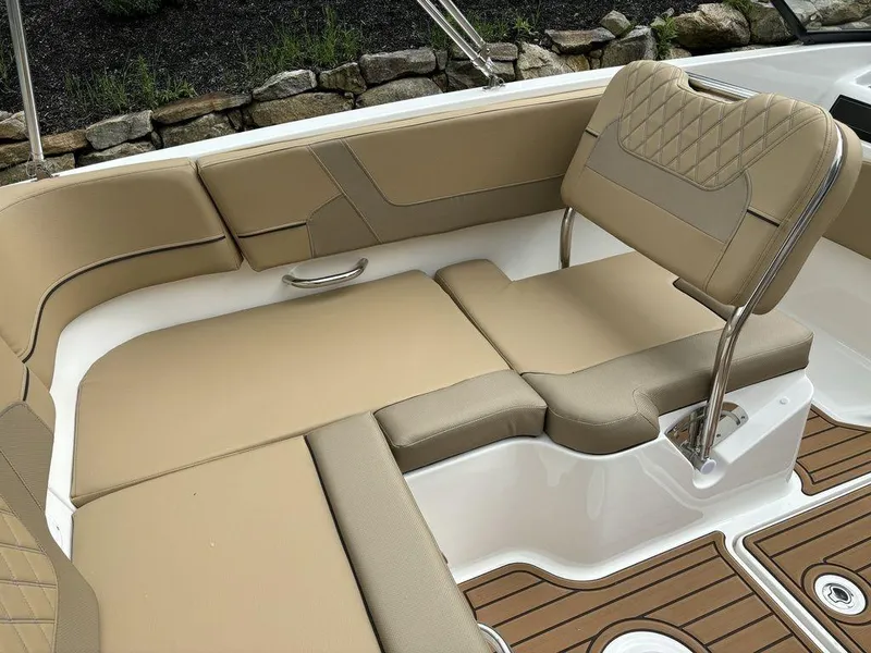 Slide: The Image of 2024 Bayliner VR5 Bowrider interior with tan seating and wood accents. - 8