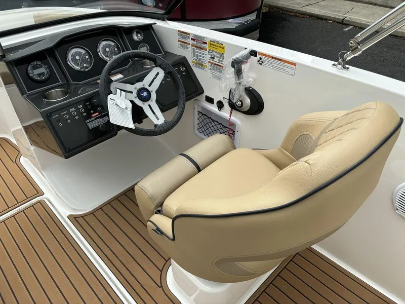 Slide: The Image of 2024 Bayliner VR5 Bowrider cockpit with beige captain's chair and modern dashboard. - 9