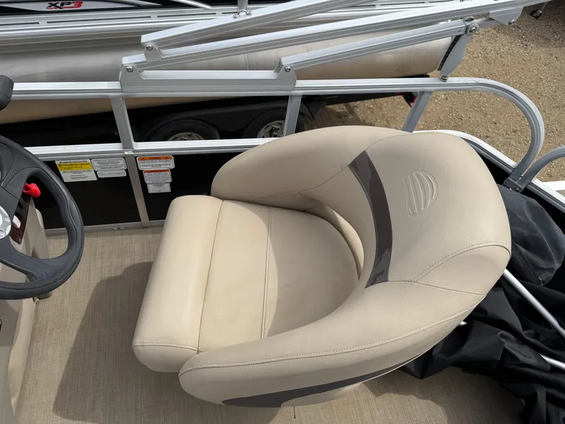 Slide: The Image of Sun Tracker Bass Buggy 18 DLX 2020 boat seat, beige upholstery, steering wheel visible. - 15