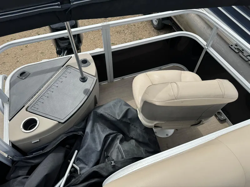 Slide: The Image of 2020 Sun Tracker Bass Buggy 18 DLX interior with beige seating and control panel. - 17