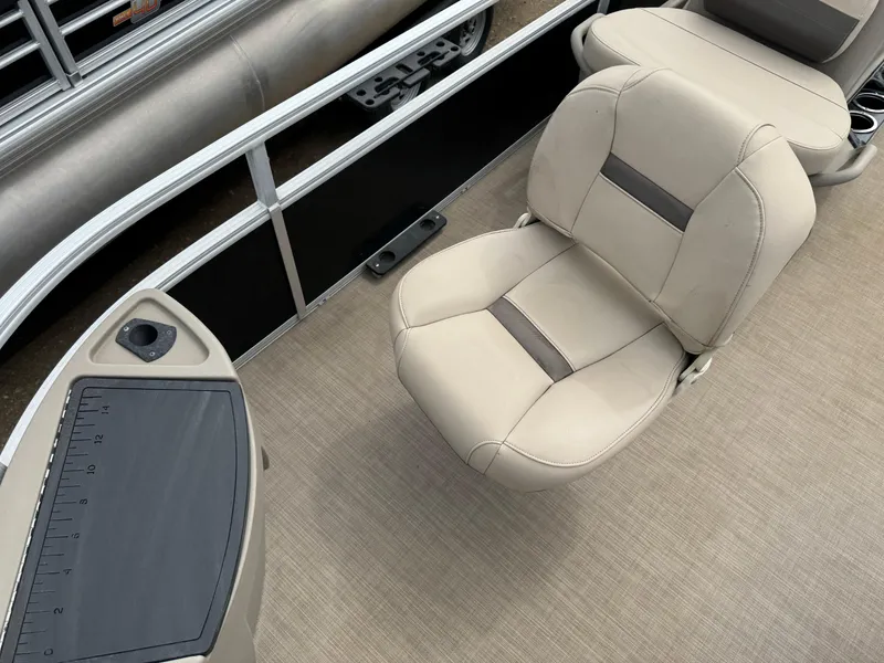 Slide: The Image of 2020 Sun Tracker Bass Buggy 18 DLX pontoon boat interior with beige seating and control panel. - 8