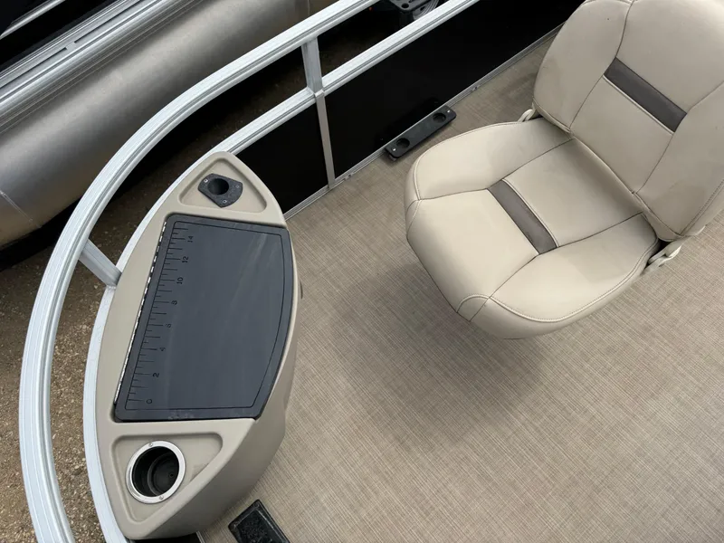 Slide: The Image of 2020 Sun Tracker Bass Buggy 18 DLX boat interior with beige seating and control panel. - 9