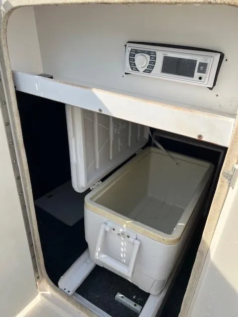 Slide: The Image of 2005 Sea Ray 240 Sundeck storage compartment with cooler and stereo system. - 14