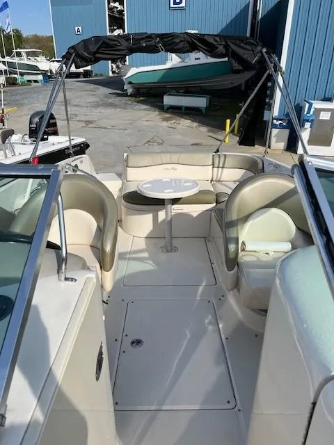 Slide: The Image of 2005 Sea Ray 240 Sundeck boat interior with seating and table. - 16