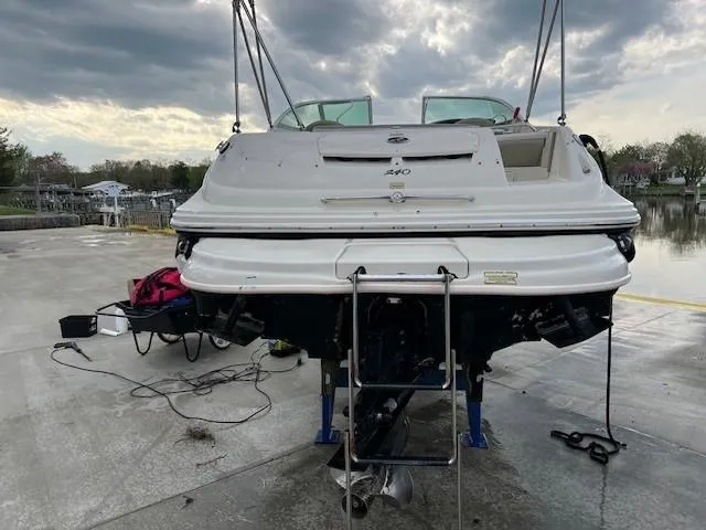 Slide: The Image of 2005 Sea Ray 240 Sundeck boat on a lift, rear view, overcast sky. - 7