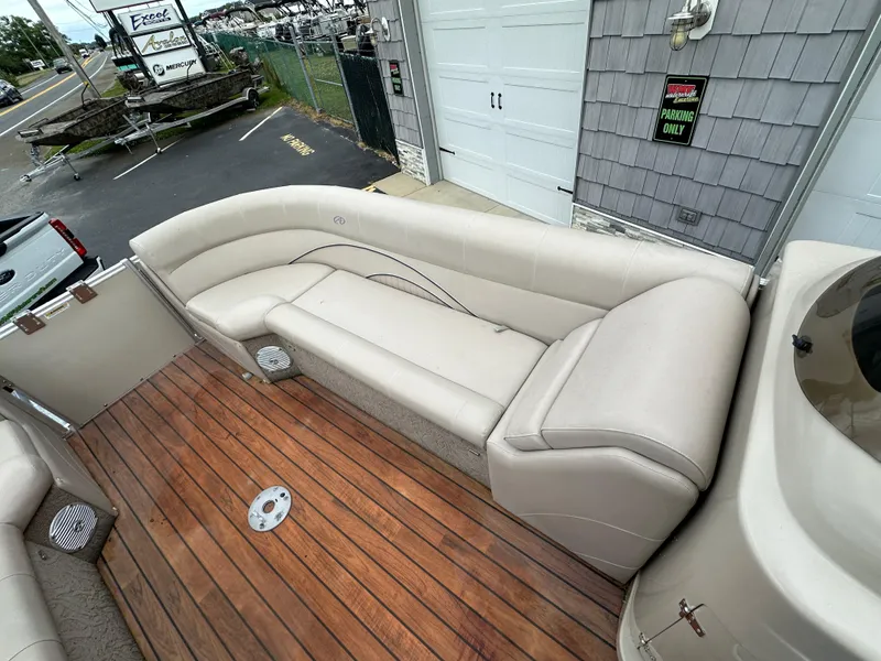 Slide: The Image of 2014 Avalon 2585 Catalina Bar / ENT Tri Toon High Performance boat with beige seating and wooden deck. - 13
