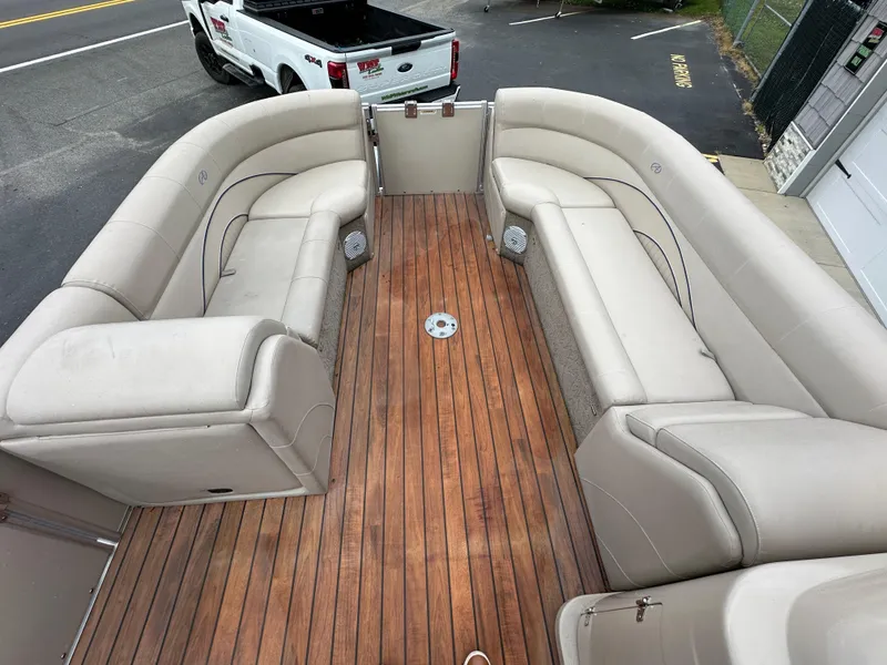 Slide: The Image of 2014 Avalon 2585 Catalina Bar / ENT Tri Toon High Performance boat interior with beige seating and wooden floor. - 14