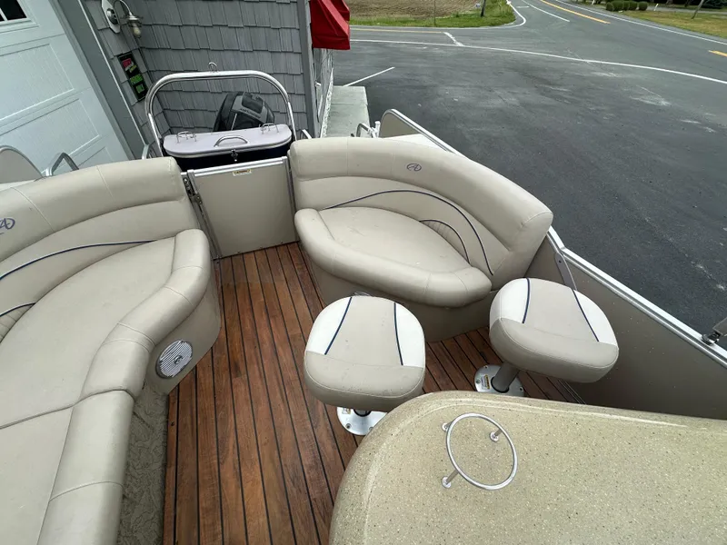 Slide: The Image of 2014 Avalon 2585 Catalina Bar / ENT Tri Toon High Performance boat interior with beige seating and wood flooring. - 18
