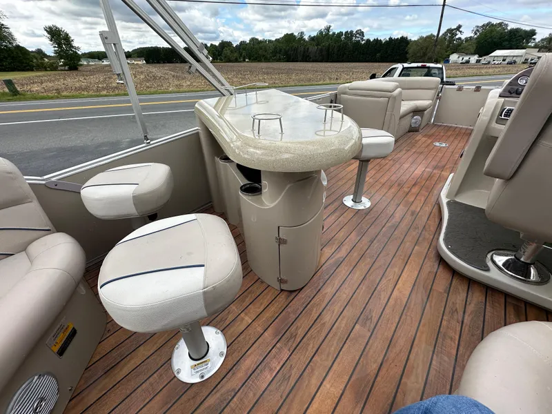 Slide: The Image of 2014 Avalon 2585 Catalina Bar Tri Toon boat interior with bar stools and wood flooring. - 19