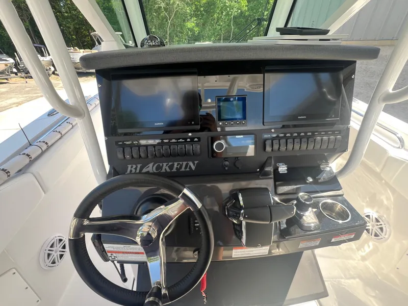 Slide: The Image of 2024 Blackfin 272 CC boat dashboard with dual screens and steering wheel. - 15