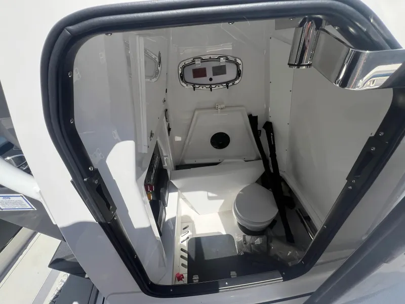 Slide: The Image of Interior of 2024 Blackfin 272 CC boat, featuring a compact marine toilet. - 17