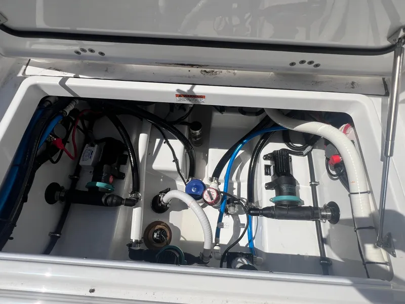 Slide: The Image of 2024 Blackfin 272 CC engine compartment with various hoses and components. - 27