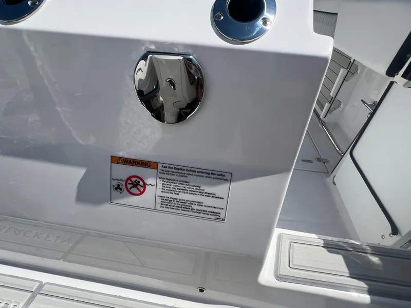 Slide: The Image of 2024 Blackfin 272 CC boat deck with warning label and chrome fixtures. - 32