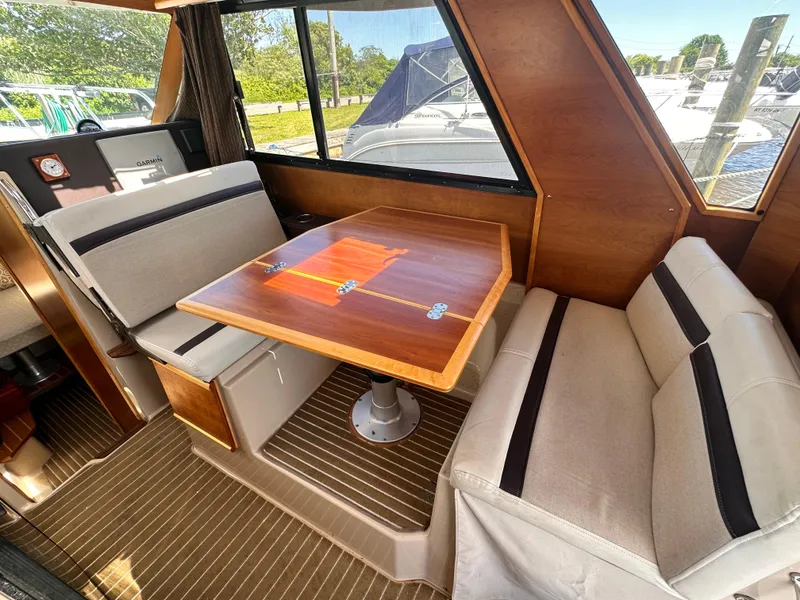 Slide: The Image of 2014 Cutwater C 26 interior dining area with wooden table and cushioned seating. - 20