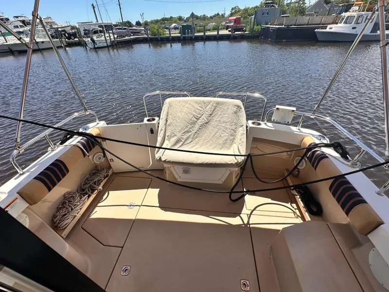 Slide: The Image of 2014 Cutwater C 26 boat deck with seating, docked at a marina. - 23