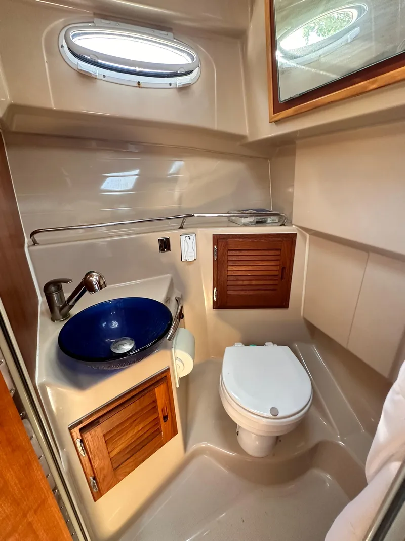 Slide: The Image of 2014 Cutwater C 26 boat bathroom with sink, toilet, and storage cabinets. - 26