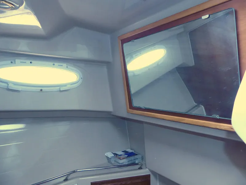 Slide: The Image of 2014 Cutwater C 26 boat interior bathroom with mirror and porthole window. - 13