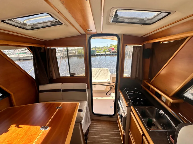 Slide: The Image of Interior of 2014 Cutwater C 26 boat with dining area, kitchen, and rear deck view. - 24