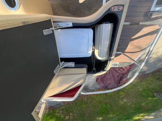 Slide: The Image of 2014 Harris FloteBote Grand Mariner 250 boat storage compartment with cooler and seating. - 18