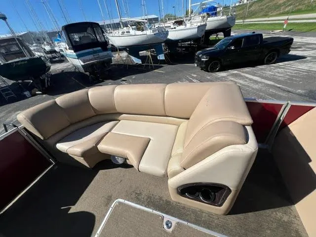Slide: The Image of 2014 Harris FloteBote Grand Mariner 250 pontoon boat with beige seating at a marina. - 31