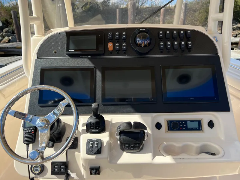 Slide: The Image of 2019 Grady-White Canyon 306 helm with steering wheel, Garmin displays, and control panel. - 10