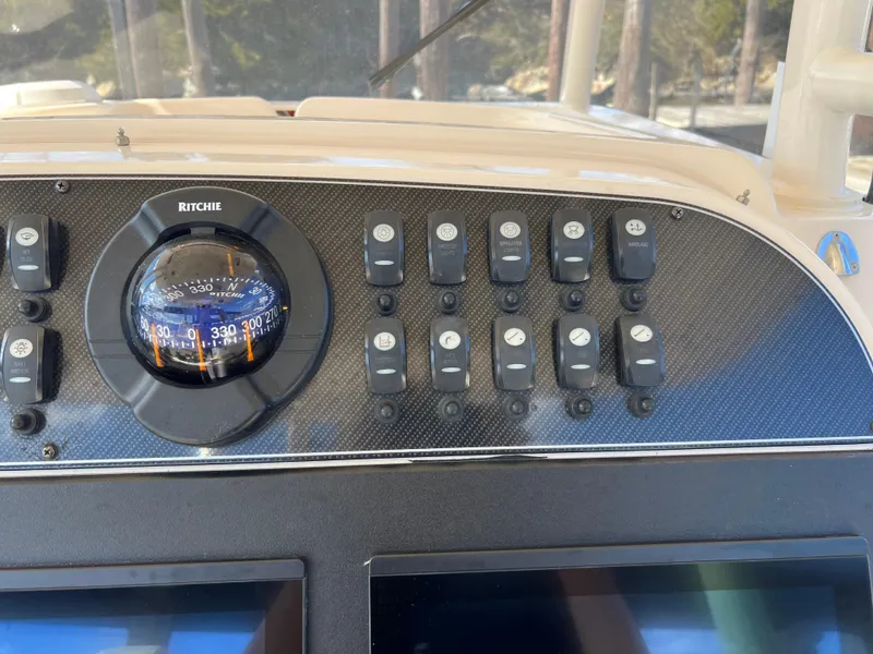 Slide: The Image of Control panel of 2019 Grady-White Canyon 306 boat with compass and switches. - 12
