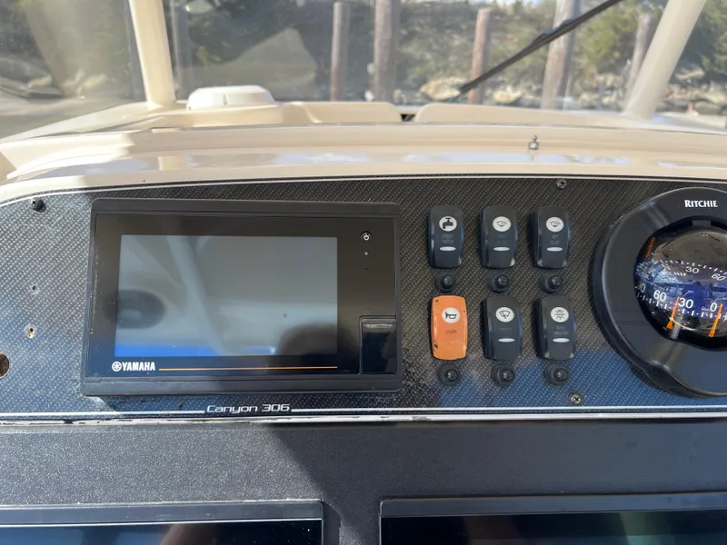 Slide: The Image of 2019 Grady-White Canyon 306 dashboard with Yamaha display and Ritchie compass. - 13