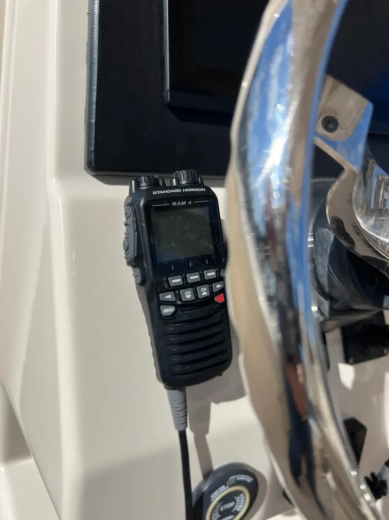 Slide: The Image of Handheld radio on 2019 Grady-White Canyon 306 boat dashboard near steering wheel. - 17