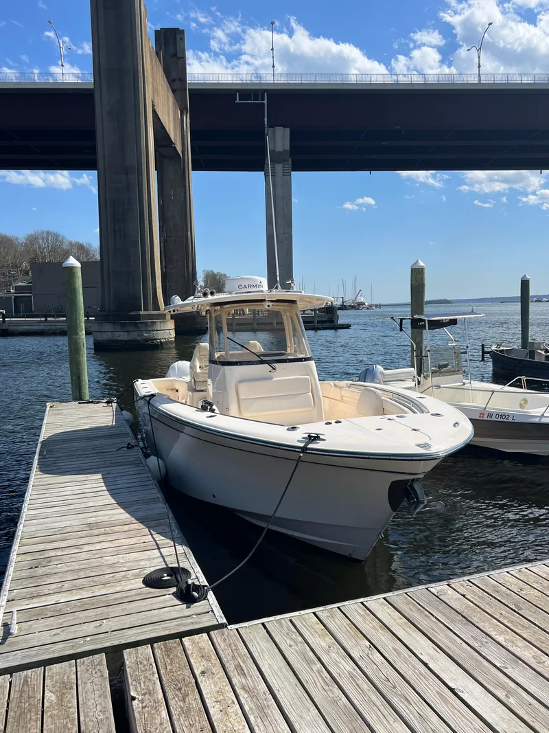 Slide: The Image of 2019 Grady-White Canyon 306 boat docked under a bridge on a sunny day. - 2