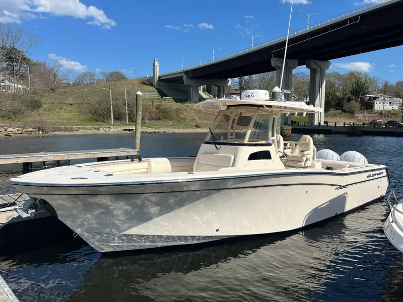Slide: The Image of 2019 Grady-White Canyon 306 boat docked under a bridge on a sunny day. - 6