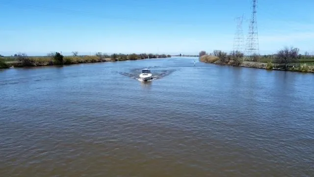 Slide: The Image of 2001 Sea Ray 460 Sundancer cruising on a wide river under a clear blue sky. - 21