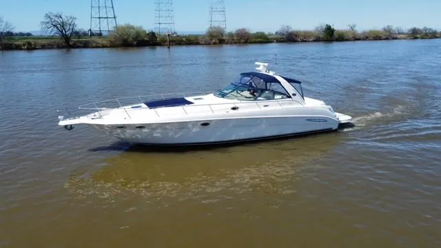 Slide: The Image of 2001 Sea Ray 460 Sundancer yacht cruising on a calm river. - 22