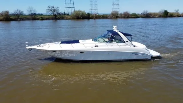 Slide: The Image of 2001 Sea Ray 460 Sundancer yacht cruising on a calm river. - 23