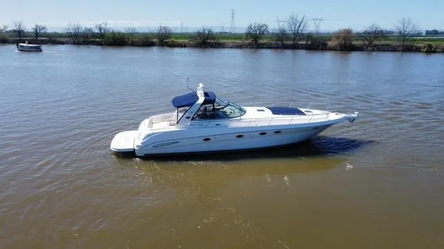 Slide: The Image of 2001 Sea Ray 460 Sundancer yacht cruising on a calm river. - 24