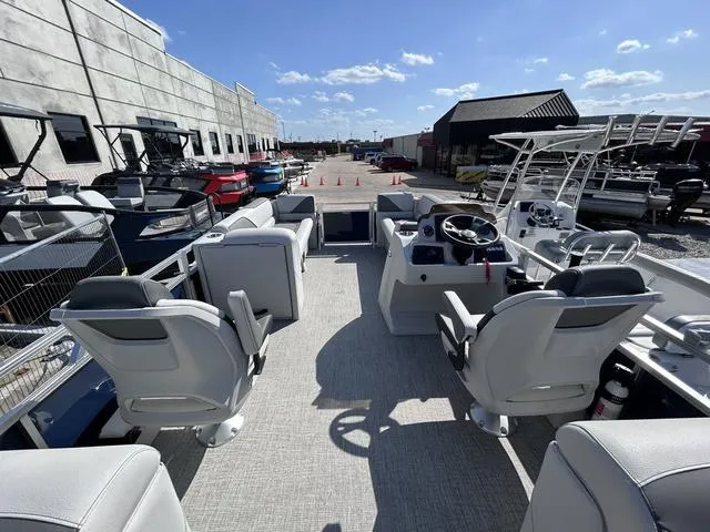 Slide: The Image of 2024 Avalon Venture Quad Lounger 23 FT boat interior with modern seating and steering console. - 10